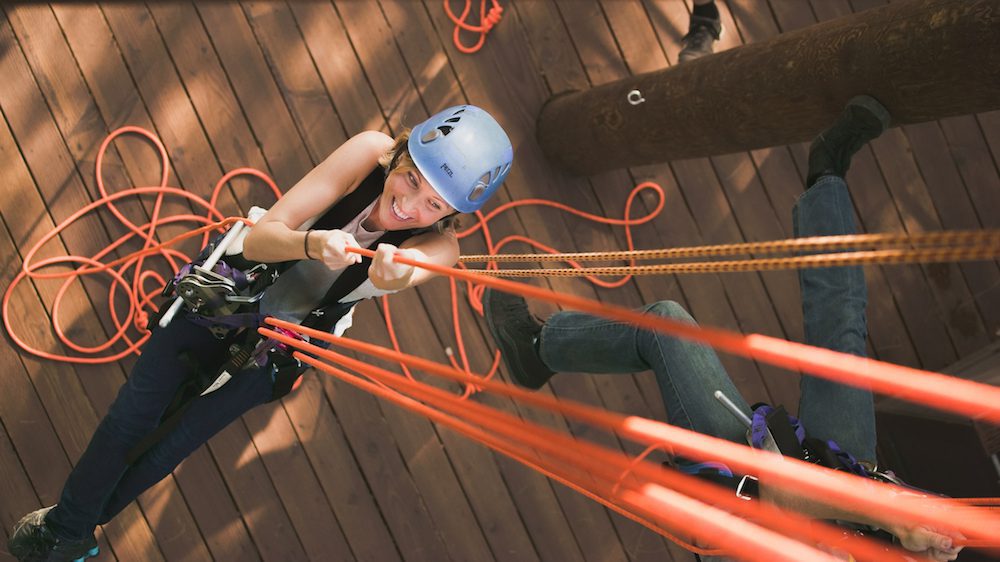 A woman pulling cables during her Oahu zipline adventure.