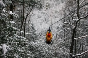 man ziplining in the winter
