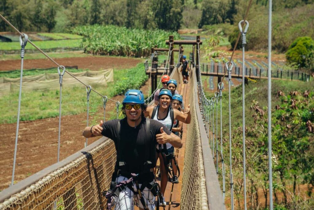 Guests showing all smiles and thumbs-up as they explore Keana Farms on a skybridge
